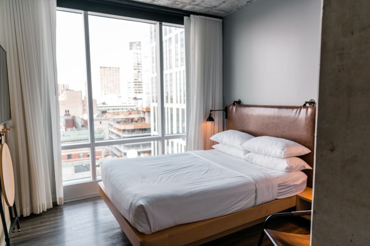 Elegant bedroom in a modern Boston apartment with city skyline view.